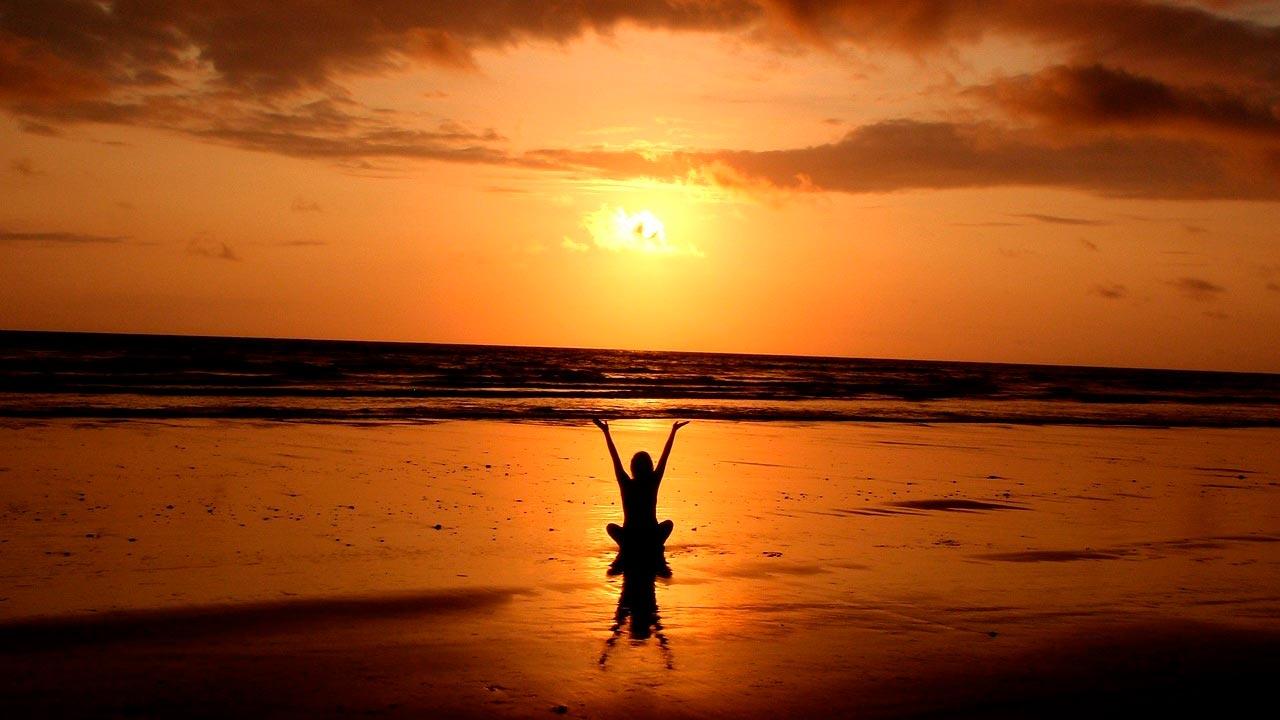 Meditar haciendo yoga en la playa